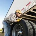 man inspecting truck tire