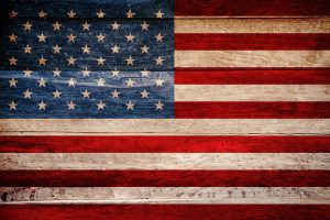 Usa flag painted on grungy wooden background.
